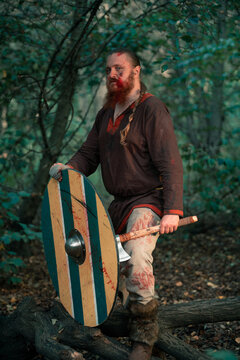 Fearless viking with Scandinavian axe and shield at battle