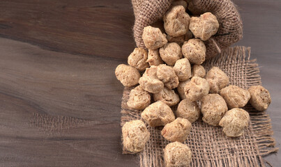 Raw soya chunks on dark background. Healthy, nutritious soybean meat, chunks isolated.Vegan food concept.
