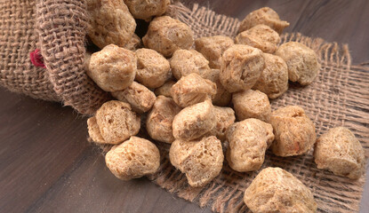 Fototapeta na wymiar Raw soya chunks on dark background. Healthy, nutritious soybean meat, chunks isolated.Vegan food concept. 