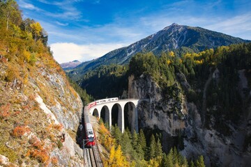 Passenger train through Landwasser Viaduct in the Swiss Alps, Landwasserviadukt, Rhatische Bahn, mountain background