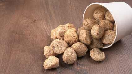 Raw soya chunks on dark background. Healthy, nutritious soybean meat, chunks isolated.Vegan food concept.
