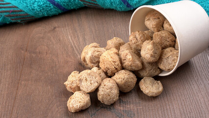 Raw soya chunks on dark background. Healthy, nutritious soybean meat, chunks isolated.Vegan food concept.
