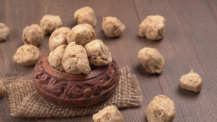 Raw soya chunks on dark background. Healthy, nutritious soybean meat, chunks isolated.Vegan food concept.
