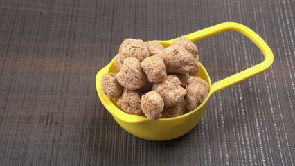 Raw soya chunks on dark background. Healthy, nutritious soybean meat, chunks isolated.Vegan food concept.
