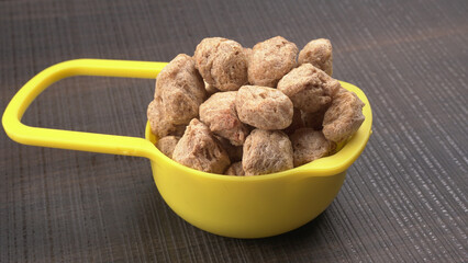 Raw soya chunks on dark background. Healthy, nutritious soybean meat, chunks isolated.Vegan food...