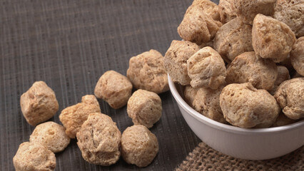 Raw soya chunks on dark background. Healthy, nutritious soybean meat, chunks isolated.Vegan food concept.
