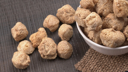 Raw soya chunks on dark background. Healthy, nutritious soybean meat, chunks isolated.Vegan food concept.
