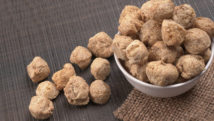 Raw soya chunks on dark background. Healthy, nutritious soybean meat, chunks isolated.Vegan food concept.
