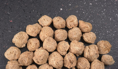 Raw soya chunks on dark background. Healthy, nutritious soybean meat, chunks isolated.Vegan food concept.