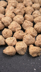 Raw soya chunks on dark background. Healthy, nutritious soybean meat, chunks isolated.Vegan food concept.