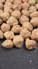 Raw soya chunks on dark background. Healthy, nutritious soybean meat, chunks isolated.Vegan food concept.
