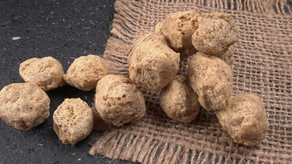 Raw soya chunks on dark background. Healthy, nutritious soybean meat, chunks isolated.Vegan food concept.