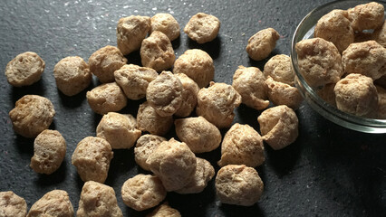 Raw soya chunks on dark background. Healthy, nutritious soybean meat, chunks isolated.Vegan food...
