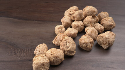 Raw soya chunks on dark background. Healthy, nutritious soybean meat, chunks isolated.Vegan food concept.