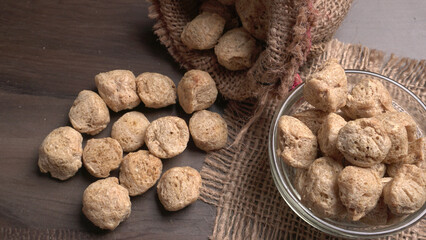 Raw soya chunks on dark background. Healthy, nutritious soybean meat, chunks isolated.Vegan food concept.