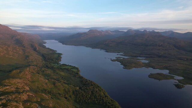 Slow motion shot of the beautiful landscape of a island in between the mountains of Loch Maree, Beinn Eighe, Kinlochewe at Scotland