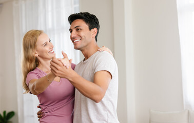 Romantic middle age couple at home. Happy loving husband and wife are enjoying spending time together while dancing in living room. Love, enjoying tender moment, joyful lifestyle. - Powered by Adobe