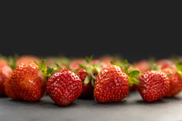 Close up ripe juicy strawberries on black background. Place for your text. Copy space.