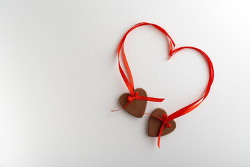 Two heart cookies with red ribbons on white background. Shape of heart.