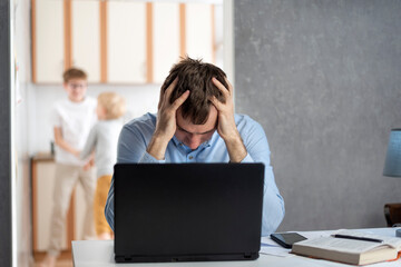 Male freelancer tries to work at home with children. Sons interferes with fathers work. Working...