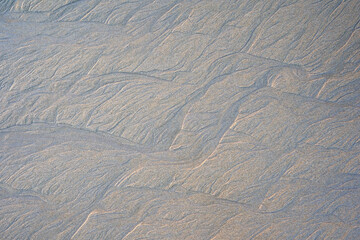 Fototapeta premium Beautiful structures in the brown sand beach. Ideal as background. View from above. Pattern.