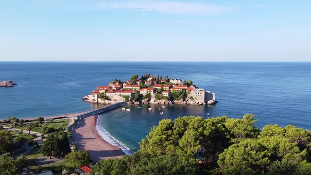 Amazing aerial view of sea island with old architecture buildings in one of the South countries. It's connected to the mainland with stone bridge. Drone Shot of Sveti Stefan (Saint Stephen)in