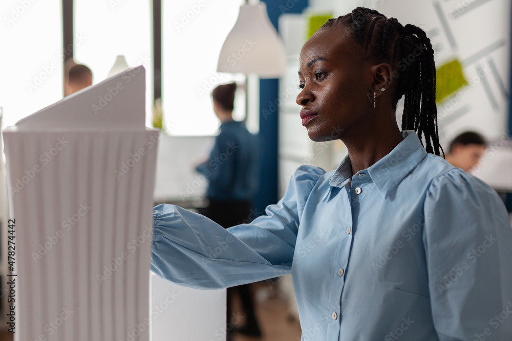 Poster professional architect inspecting skyscraper white foam model in architectural modern office. portra
