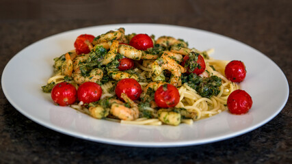ready to eat - spaghetti with shrimps and cherry tomatoes in olive oil with onions and herbs