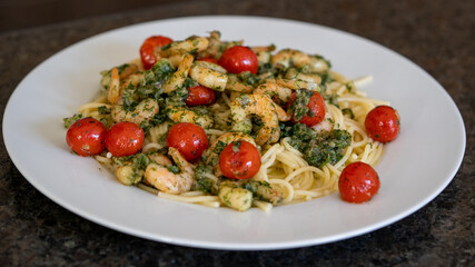 ready to eat - spaghetti with shrimps and cherry tomatoes in olive oil with onions and herbs
