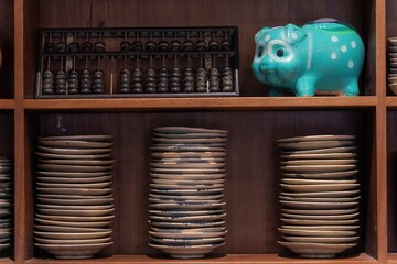 Kitchenware with dishware keeping on kitchen wooden shelving.Traditional Vietnamese blue porcelain...