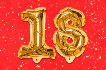 The number of the balloon made of golden foil, the number eighteen on a red background with sequins. Birthday greeting card with inscription 18. Numerical digit, Celebration event, template.