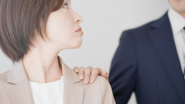肩を触られるビジネスウーマン　セクハライメージ