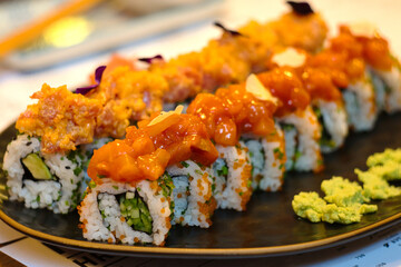 The variety of food showing the taste of Japan - mixed set of colorful seafood sushi, tuna, losos and shrimp nigiri, tempura and shrimp rolls