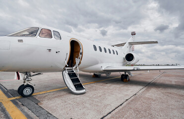 Cloudy weather. Turboprop aircraft parked on the runway at daytime