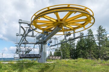 Spinning wheel with electric cable hoist motor in a ski resort