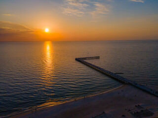 Obraz premium Aerial view of Palanga bridge to the Baltic sea and a sunset in horizon