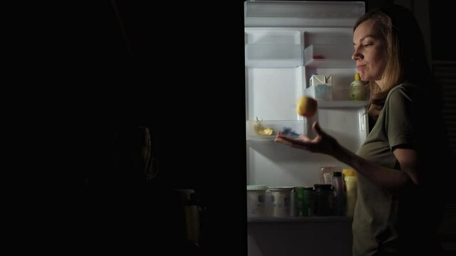 Night Eating, Hungry Woman Open Refrigerator At Night And Take Apple To Eat