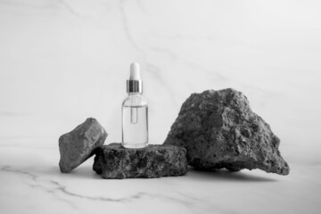 Skin and body care concept. Trendy cosmetic dropper on grunge concrete stone like podium on marble background. Mock up 