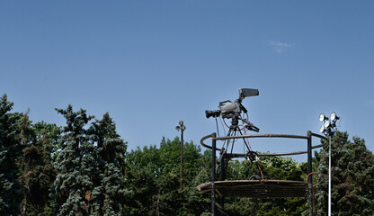 Television broadcast camera system standing on a tripod for a live stand up position with blue sky...