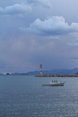 Seascape at sunset. Lighthouse on the coast. Seaside town of Turgutreis and spectacular sunsets