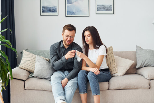 Couple sitting together on the sofa in domestic room