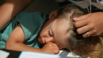 Sleepy child rubbing eye with hand, kid lying down resting - obrazy, fototapety, plakaty