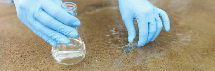 Scientist with gloves takes samples in pond closeup