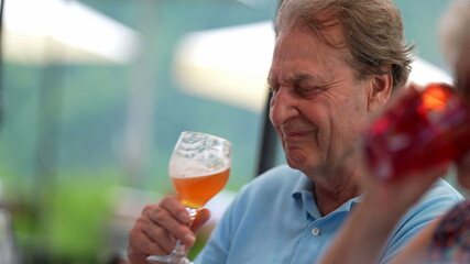 Senior man drinking beer with friends