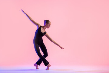 Young teenager dancer dancing on a red studio background. Ballet, dance, art, modernity,...