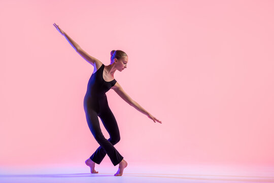 Young teenager dancer dancing on a red studio background. Ballet, dance, art, modernity, choreography concept