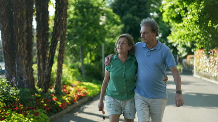 Obraz premium Romantic older couple going for a walk, 60s senior husband and wife together