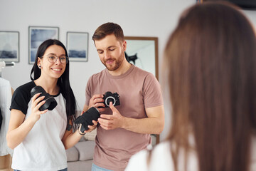 Preparing model. Photographers works indoors in their studio at daytime
