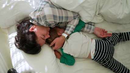 Mother and child in morning bed together waking up