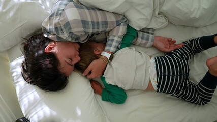 Mother and child in morning bed together waking up